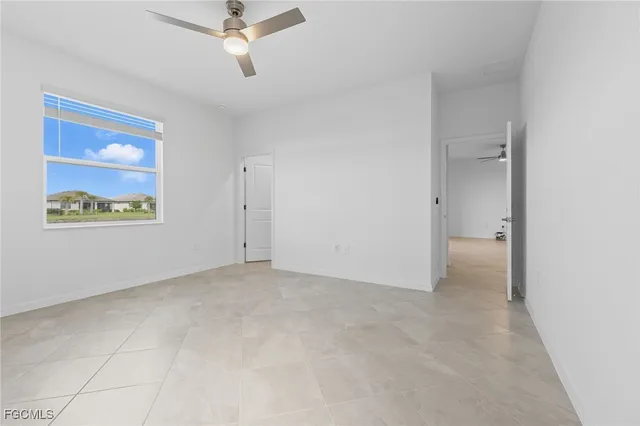 an empty room with closet and a ceiling fan