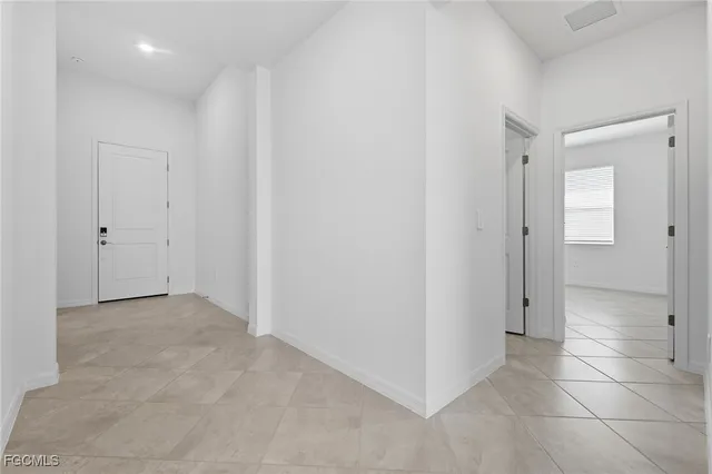 an empty room with kitchen and entrance