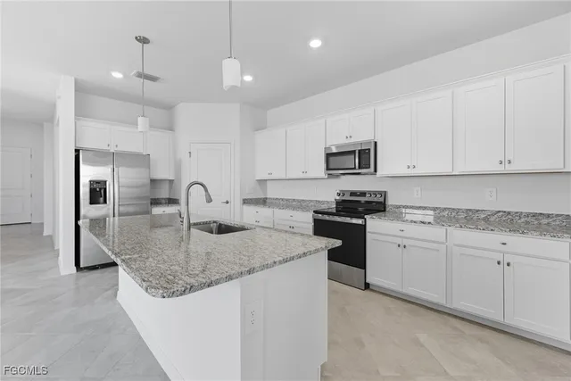 a kitchen with kitchen island granite countertop a stove sink and refrigerator