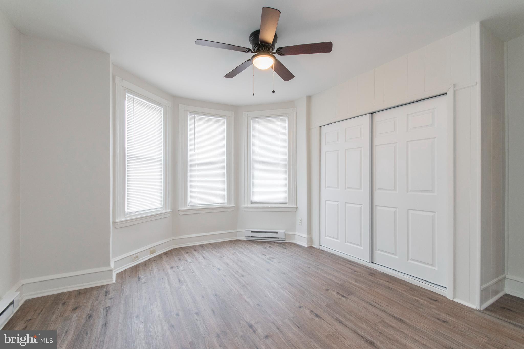 725 West Luzerne Street Philadelphia, PA 19140 - Photo 13 of 23 an empty room with wooden floor chandelier fan and windows