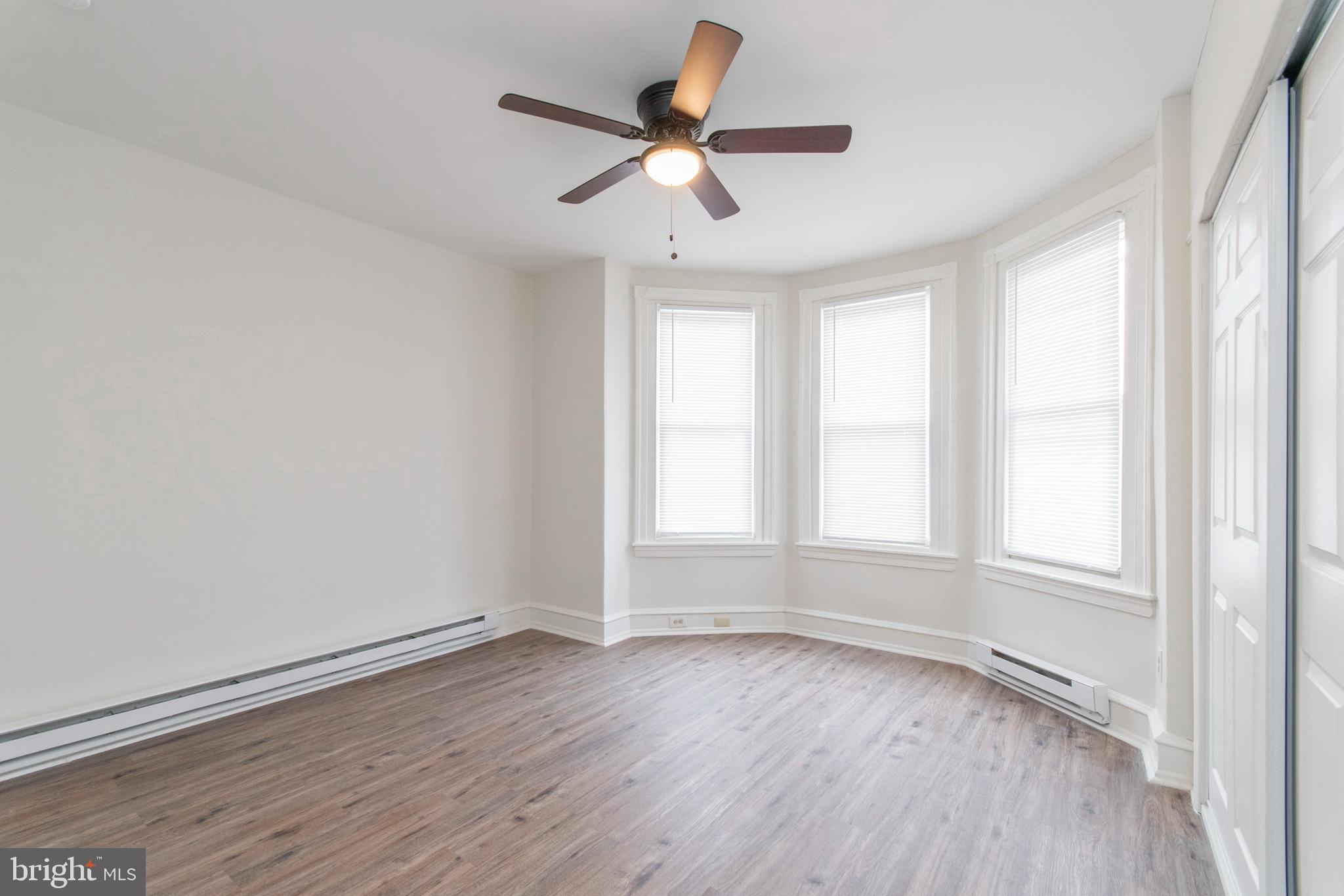 725 West Luzerne Street Philadelphia, PA 19140 - Photo 14 of 23 an empty room with wooden floor ceiling fan and windows