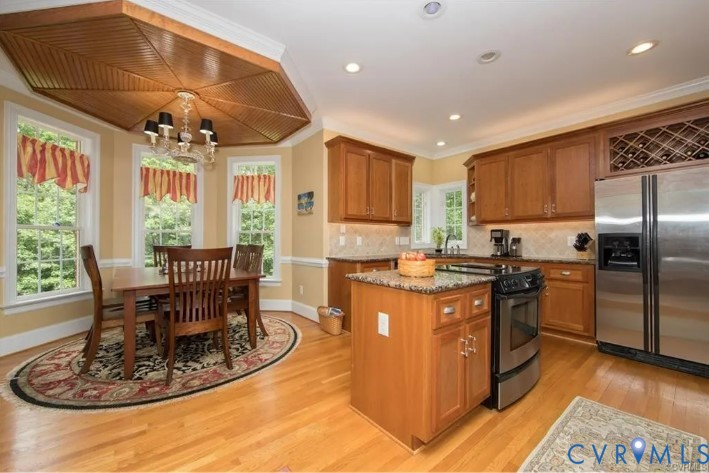 1638 Fallen Timber Trail Powhatan, VA 23139 - Photo 13 of 48 a kitchen with stainless steel appliances granite countertop a stove a refrigerator a dining table and chairs with wooden floor