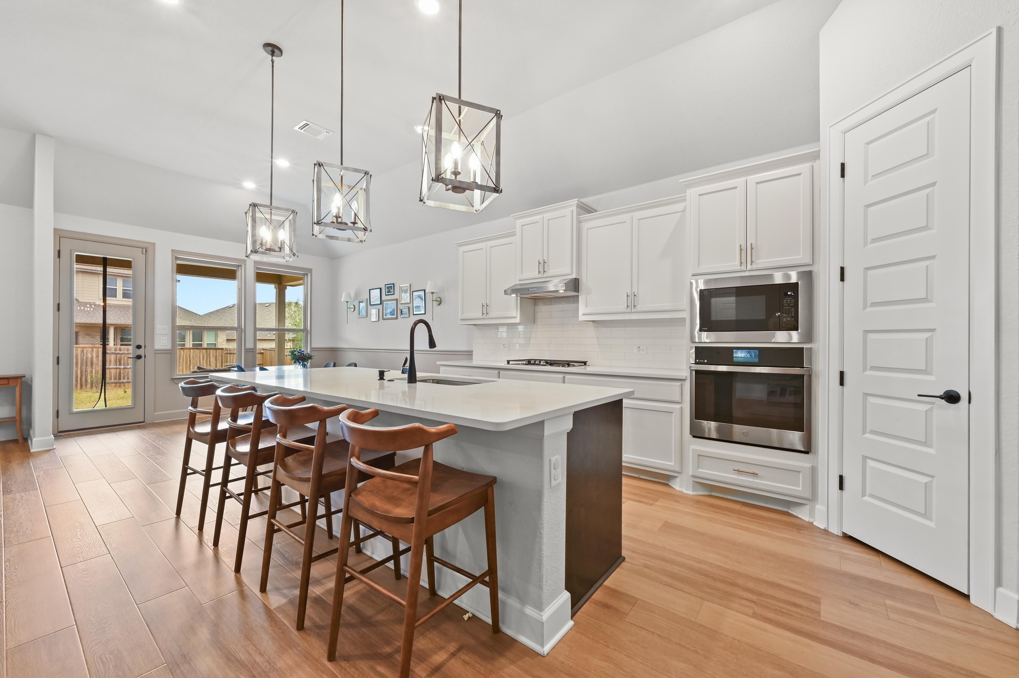 308 Allegheny Way Kyle, TX 78640 - Photo 11 of 40 a kitchen with stainless steel appliances a dining table chairs stove and white cabinets