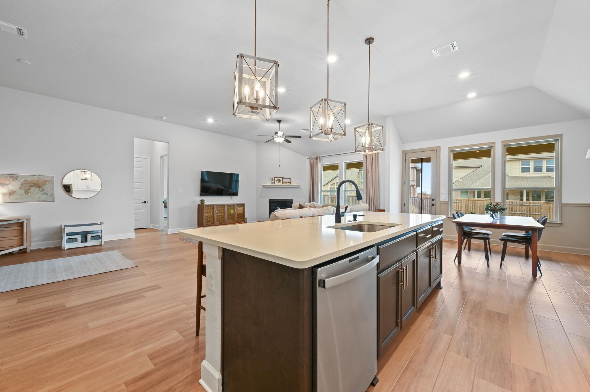308 Allegheny Way Kyle, TX 78640 - Photo 39 of 40 Kitchen featuring open floor plan, a ceiling fan, dark wood finish cabinetry, stainless steel dishwasher, and hanging lights