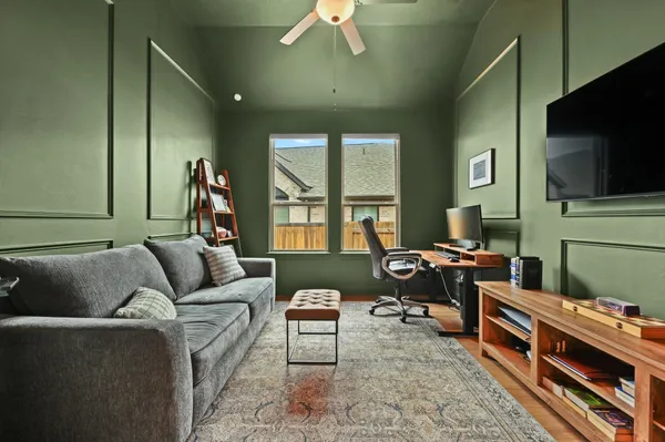 a living room with furniture and a dining table with wooden floor