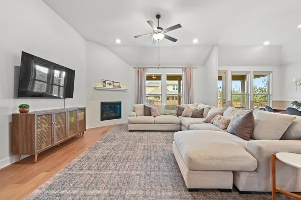 a kitchen with stainless steel appliances a dining table chairs stove and white cabinets
