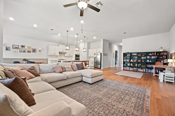 a kitchen with stainless steel appliances granite countertop a sink a stove a refrigerator cabinets and chairs