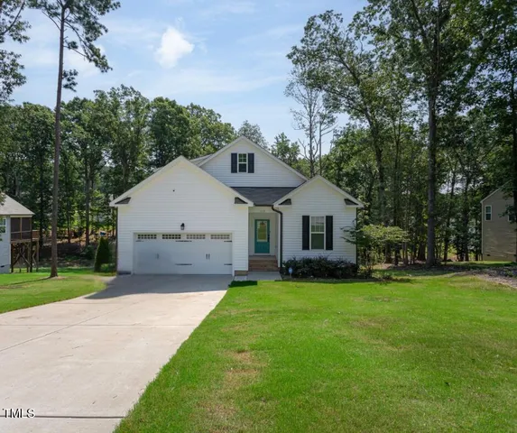 a view of a house with a yard and pathway