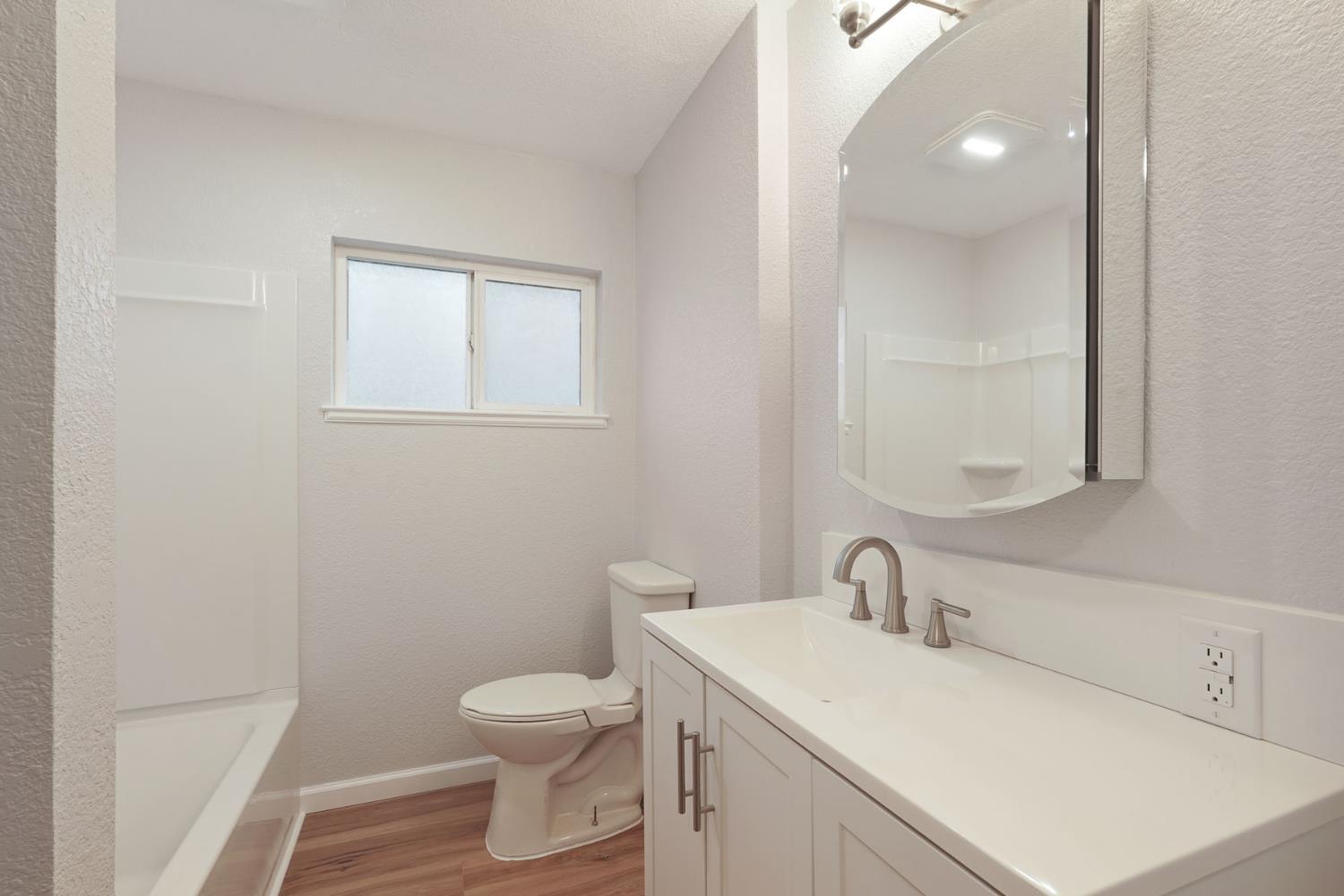 322 West Turner Road Lodi, CA 95240 - Photo 12 of 16 a bathroom with a toilet sink vanity and mirror
