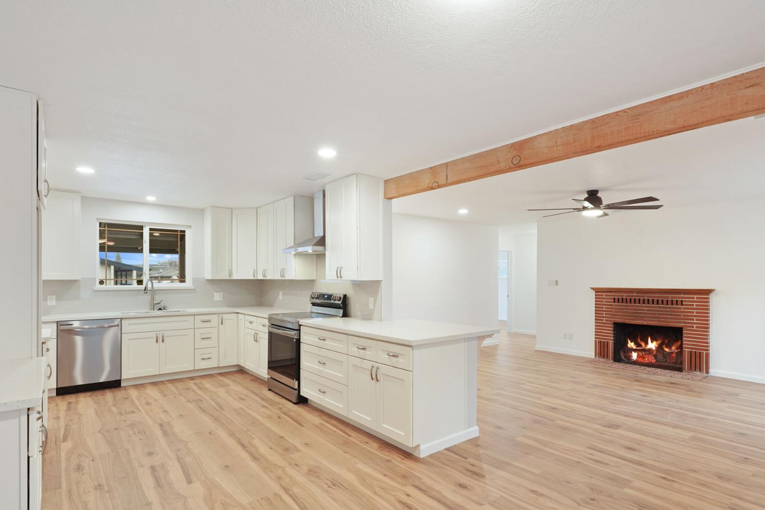 322 West Turner Road Lodi, CA 95240 - Photo 7 of 16 a large white kitchen with a stove top oven a sink and dishwasher with wooden floor