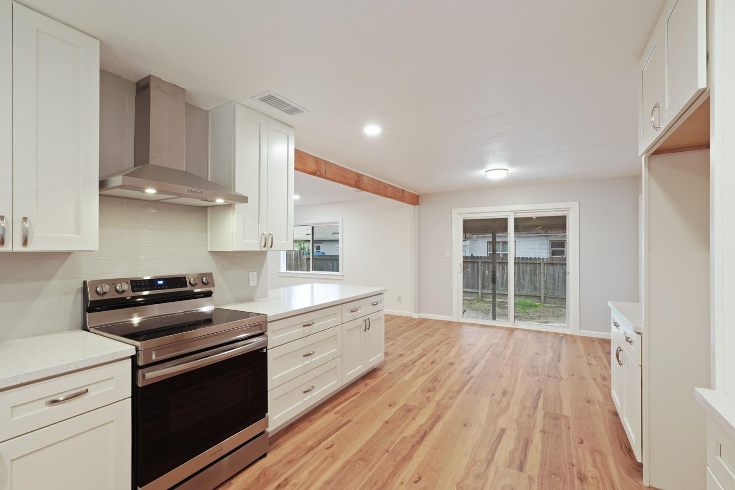 322 West Turner Road Lodi, CA 95240 - Photo 9 of 16 a kitchen with granite countertop a stove and a wooden floors