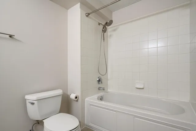 a white toilet and tub sitting next to a bathroom sink