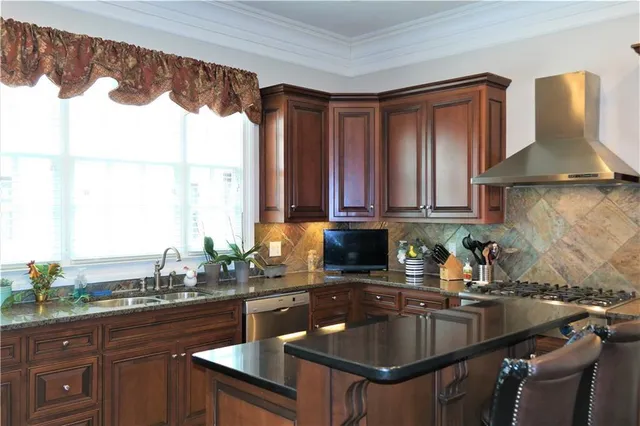 a kitchen with granite countertop a sink and a stove