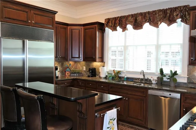 a kitchen with granite countertop a sink and a refrigerator