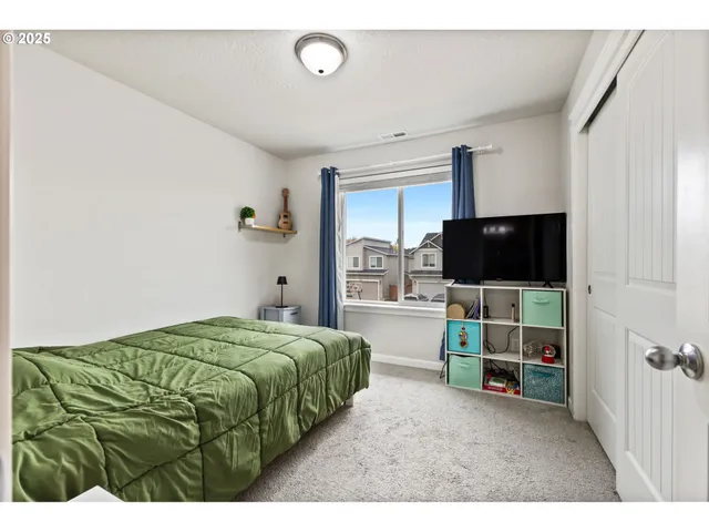 a living room with a flat screen tv and a refrigerator