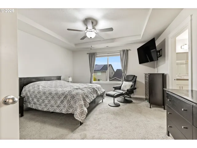a bedroom with a bed a flat screen tv and dresser