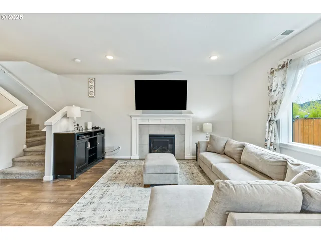 a living room with furniture a fireplace and a flat screen tv