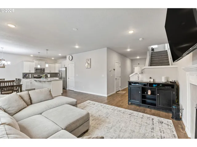 a living room with furniture a flat screen tv and kitchen view
