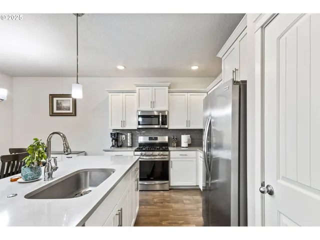 a kitchen with kitchen island a sink stainless steel appliances and cabinets