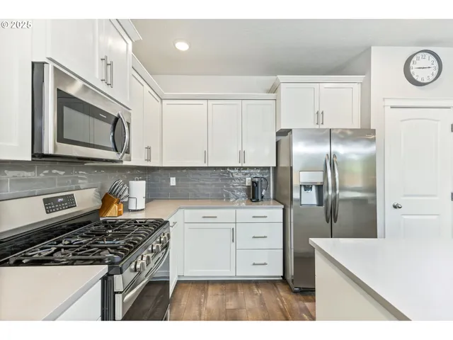 a kitchen with stainless steel appliances granite countertop a stove a refrigerator and a microwave