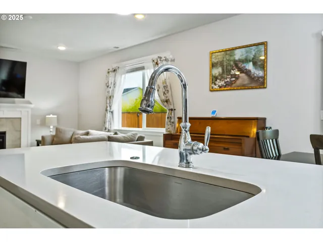 a kitchen with stainless steel appliances a sink a microwave a stove and a sink with wooden floor