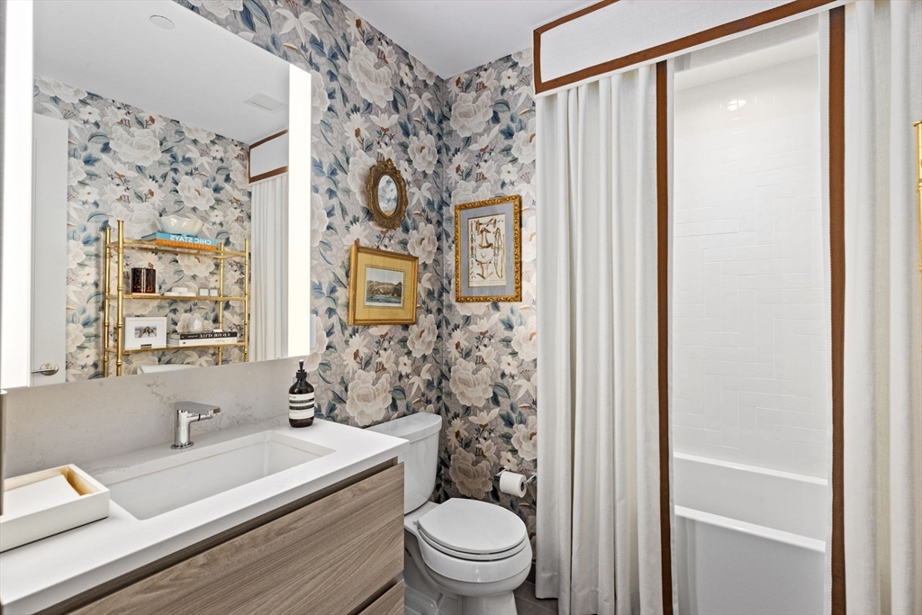 133 Seaport Boulevard, Unit 1603 Boston, MA 02210 - Photo 16 of 32 a bathroom with a sink a toilet and shower curtain