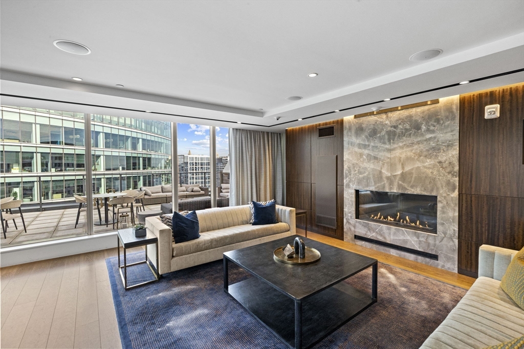 133 Seaport Boulevard, Unit 1603 Boston, MA 02210 - Photo 28 of 32 a living room with furniture and a floor to ceiling window