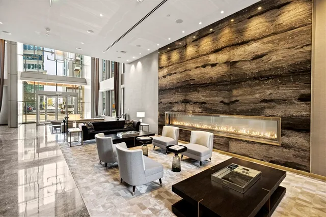 a living room with fireplace furniture and floor to ceiling windows