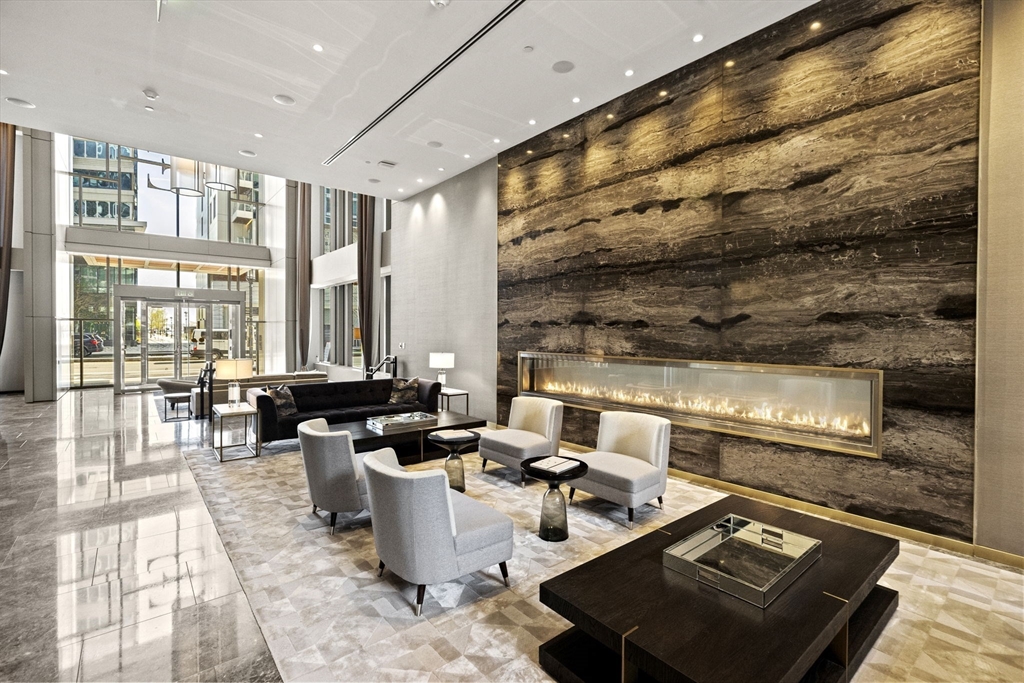 133 Seaport Boulevard, Unit 1603 Boston, MA 02210 - Photo 4 of 32 a living room with fireplace furniture and floor to ceiling windows