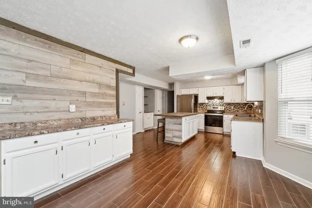 a kitchen with granite countertop white cabinets and white appliances