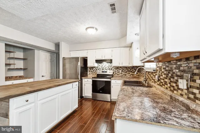 a large kitchen with a stove and refrigerator