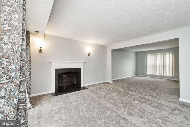 a view of empty room with window and fireplace
