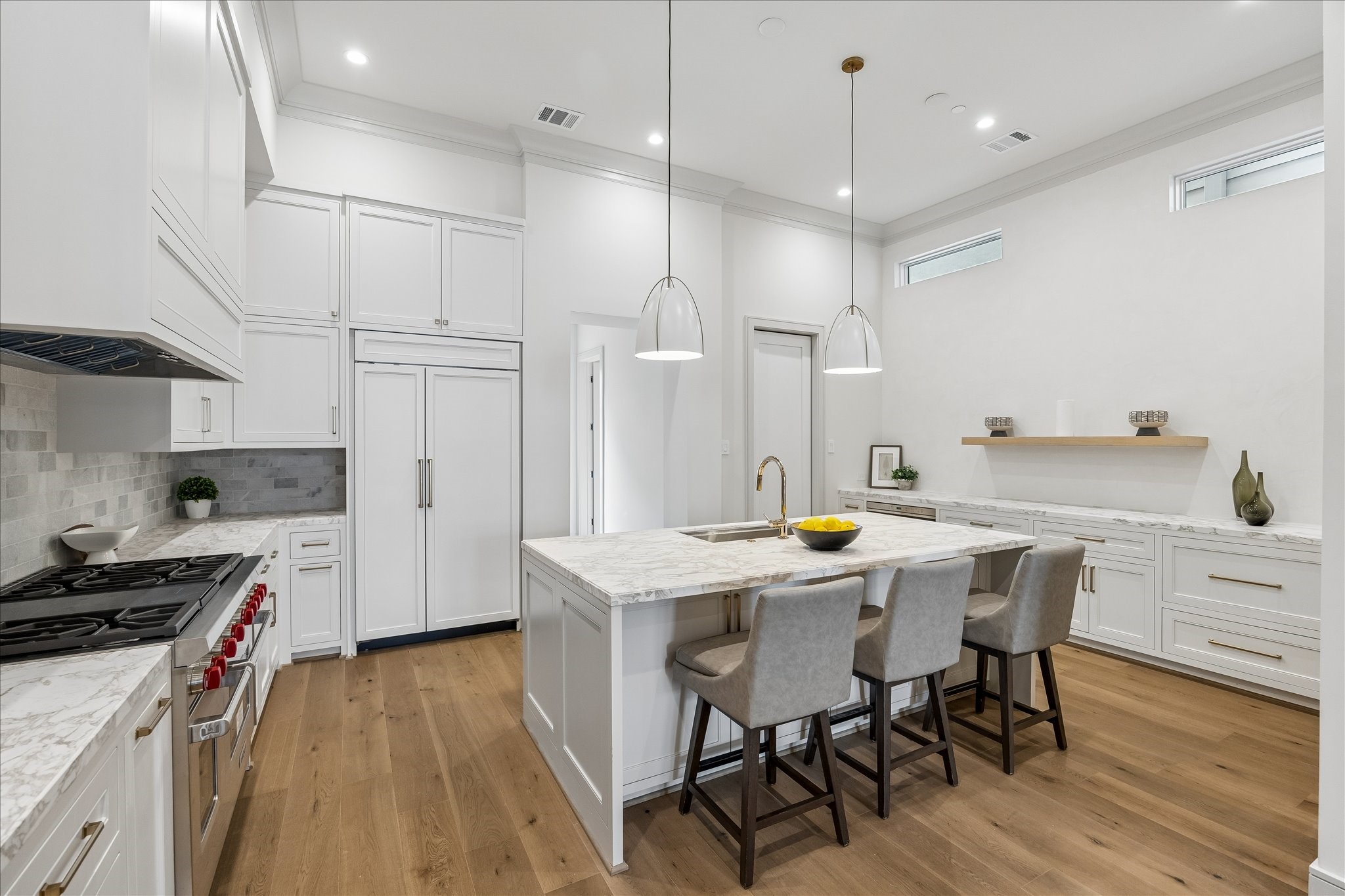 1215 West Pierce Street Houston, TX 77019 - Photo 12 of 37 The kitchen's center island features marble countertop with signature edge profile, Ruvati workstation, and a Bosch dishwasher with disappearing cabinet panel. The tumbled marble backsplash and inset, custom-built cabinetry complete the look.
The primary bedroom showcases the wide-plank engineered European French Oak Old Vineyard flooring. Perth chandelier, crown moulding, and large windows make this a welcome oasis.
