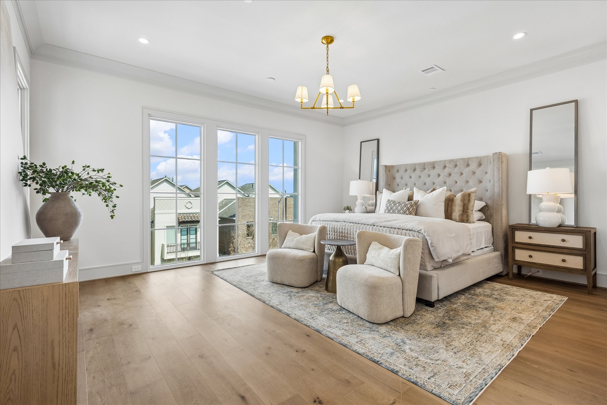 1215 West Pierce Street Houston, TX 77019 - Photo 3 of 37 The primary bedroom showcases the wide-plank engineered European French Oak Old Vineyard flooring. Perth chandelier, crown moulding, and large windows make this a welcome oasis.