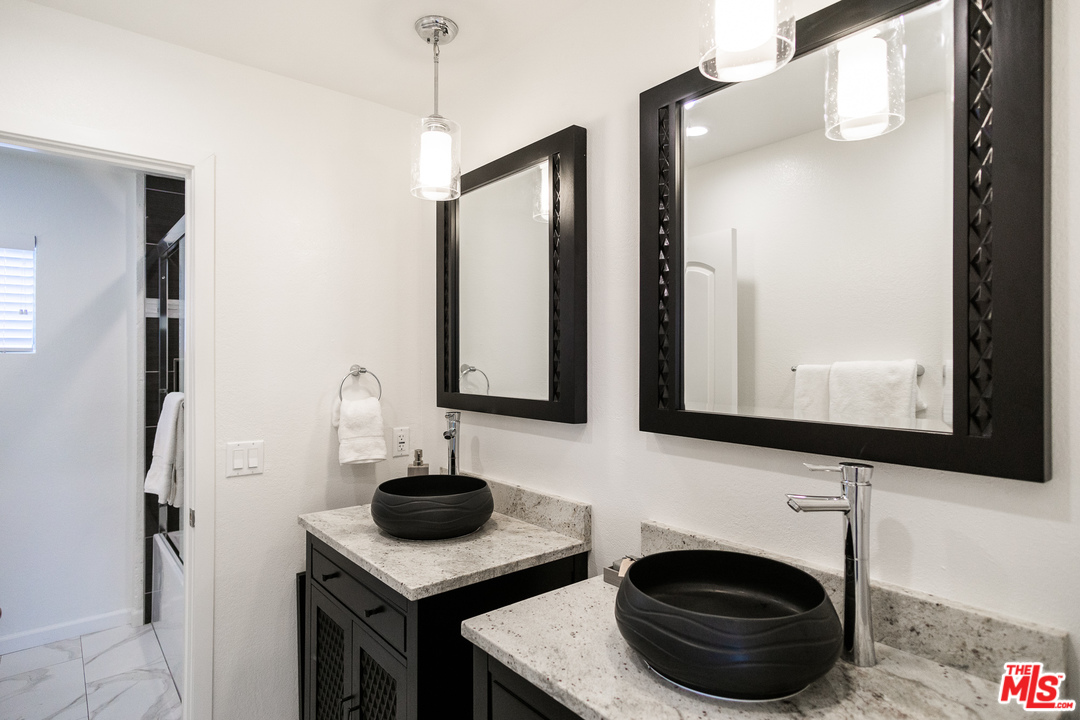 1085 West Kensington Road Los Angeles, CA 90026 - Photo 12 of 23 a bathroom with a sink a light fixture and a mirror