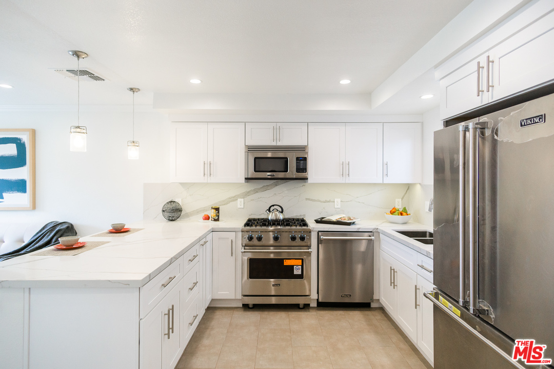 1085 West Kensington Road Los Angeles, CA 90026 - Photo 4 of 23 a kitchen with stainless steel appliances a stove a sink and a refrigerator
