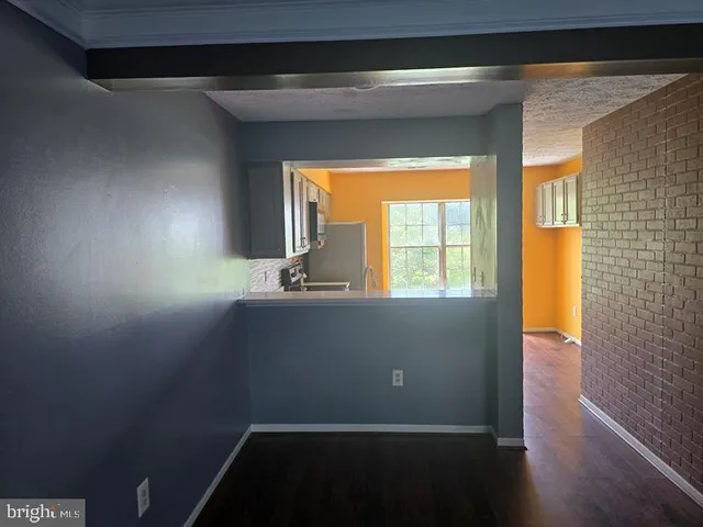 a kitchen with a refrigerator stove and wooden floor