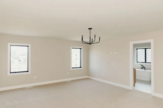 an empty room with windows and ceiling fan