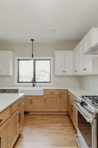 a large kitchen with a stove top oven sink and cabinets