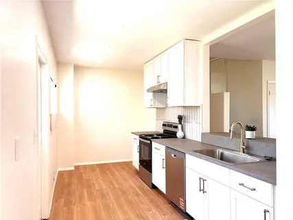 a kitchen with a sink a stove and cabinets