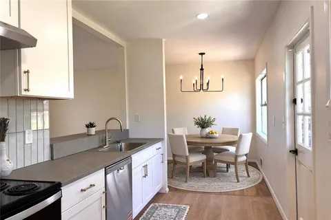 a kitchen with granite countertop a sink stove and cabinets