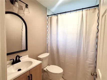a bathroom with a sink a toilet and a mirror