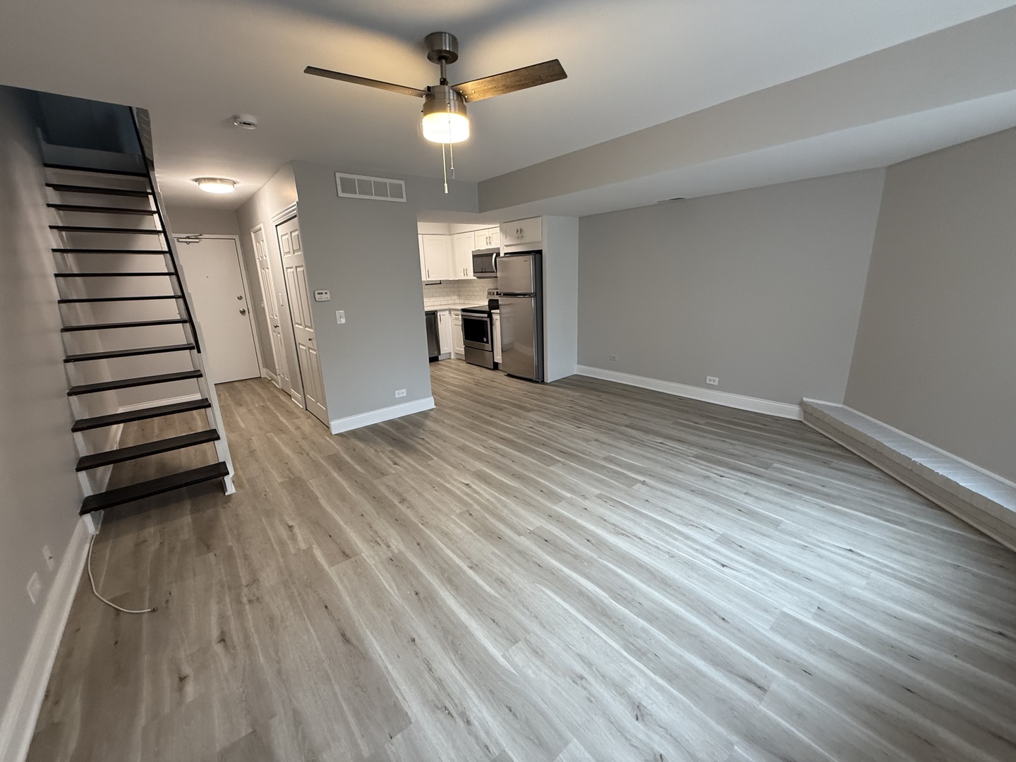 744 West Gordon Terrace, Unit 306 Chicago, IL 60613 - Photo 3 of 13 wooden floor in an empty room with a kitchen