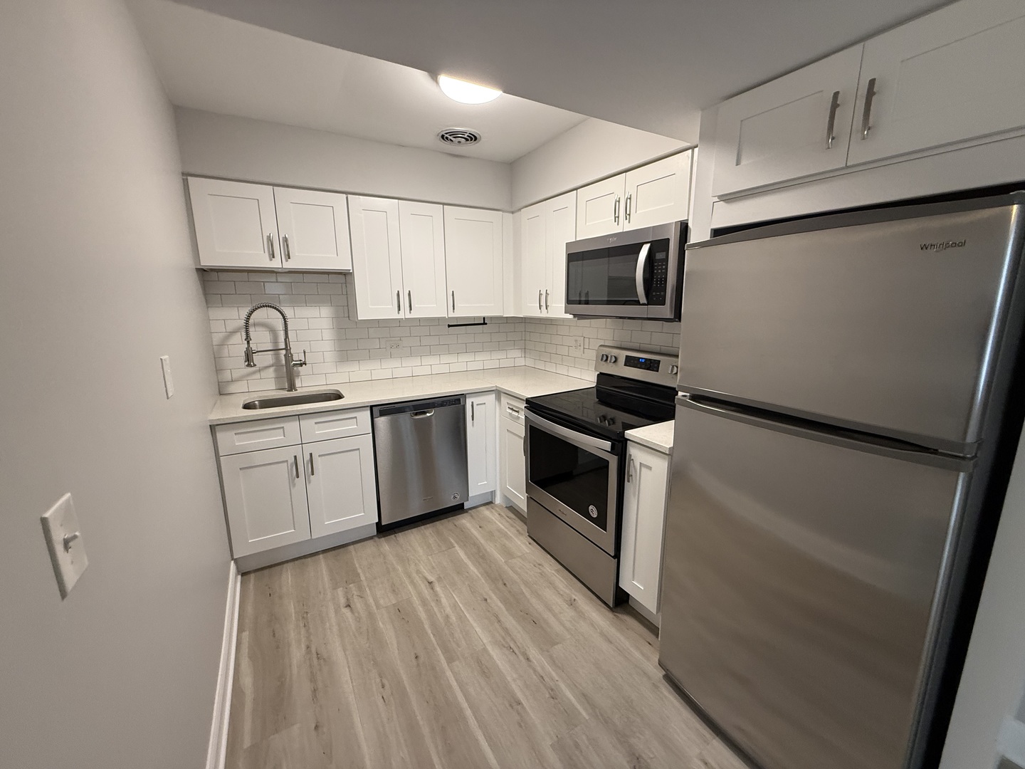 744 West Gordon Terrace, Unit 306 Chicago, IL 60613 - Photo 5 of 13 a kitchen with a sink stainless steel appliances and white cabinets