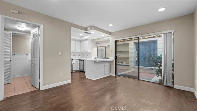 a view of a kitchen with refrigerator and white cabinets