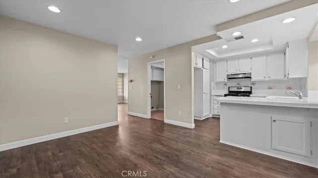 a view of kitchen with granite countertop stainless steel appliances refrigerator and cabinets