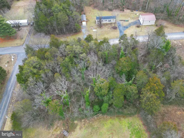 a aerial view of residential house with outdoor space and trees all around