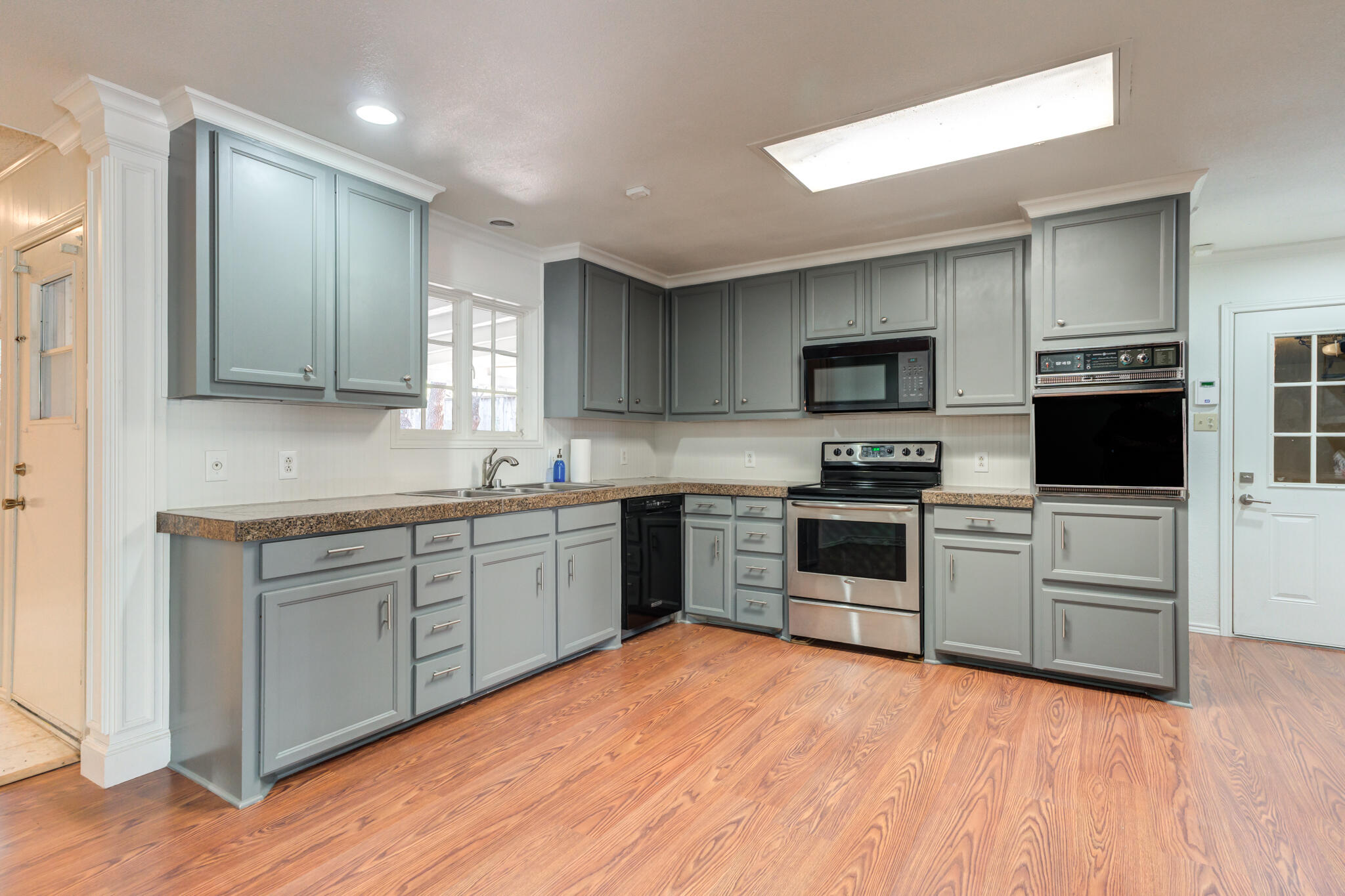 4629 88th Street Lubbock, TX 79424 - Photo 16 of 60 a kitchen with granite countertop a stove top oven sink and cabinets