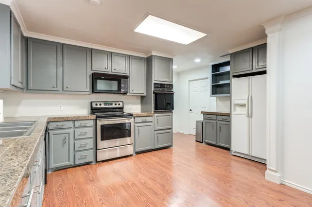 a kitchen with granite countertop a sink cabinets and window