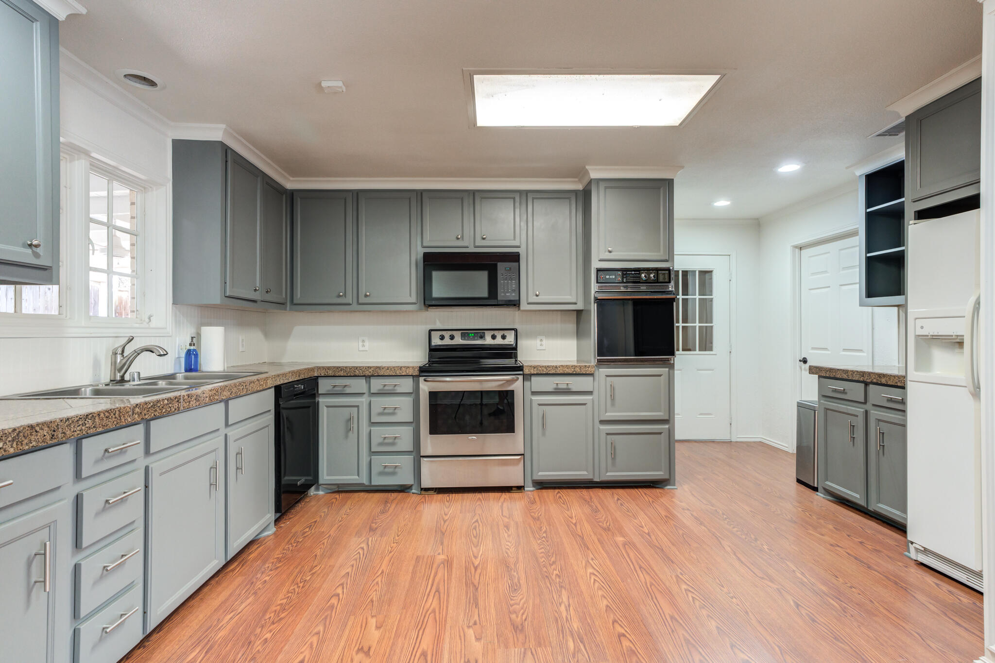4629 88th Street Lubbock, TX 79424 - Photo 19 of 60 a kitchen with granite countertop a stove top oven and cabinets